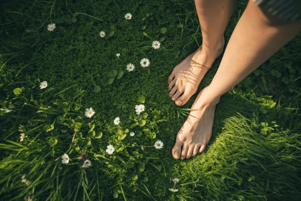 A woman grounding herself in nature, connecting with the earth to embrace her Inner Spring energy as part of her cycle syncing practice.